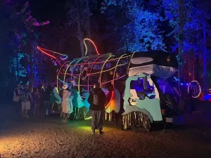 The Orcar at night showing people inside the Orcar and gathered around it.